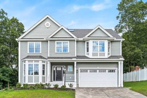 a front view of a house with a garden and yard