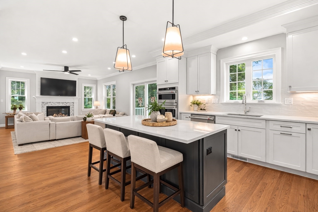 26 Flagg Street Woburn, MA 01801 - Photo 11 of 39 a kitchen with a dining table chairs cabinets wooden floor and appliances