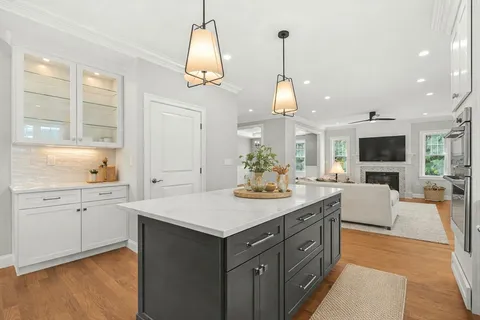 a kitchen with a sink stove and wooden floor