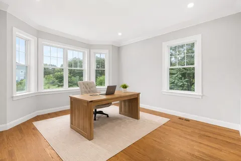 a view of a workspace with wooden floor and a window