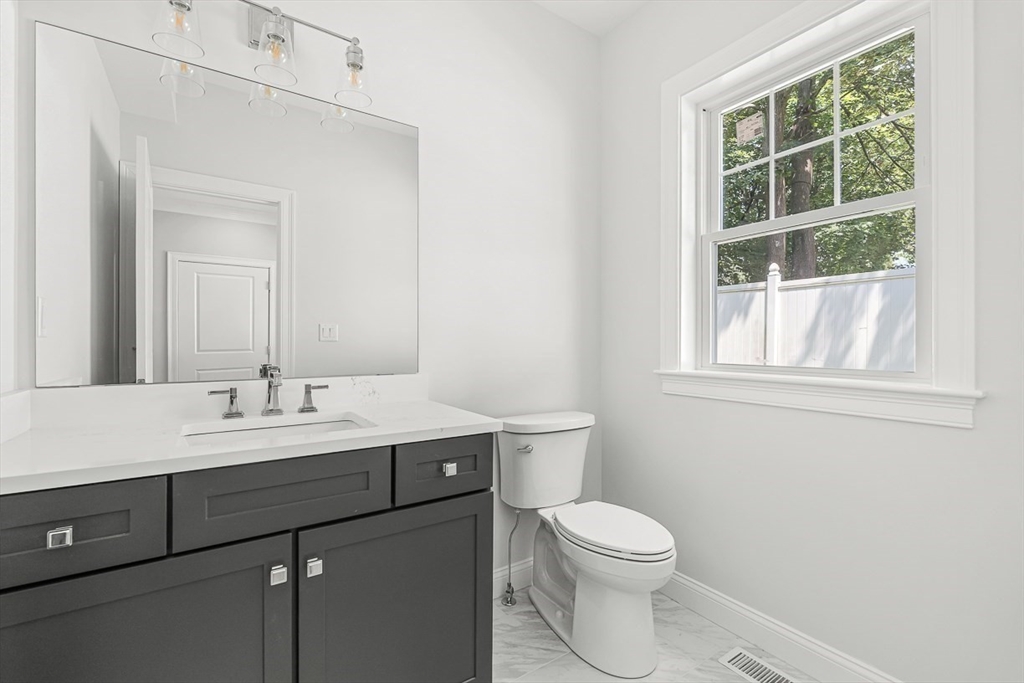 26 Flagg Street Woburn, MA 01801 - Photo 21 of 39 a bathroom with a toilet a sink a vanity and a window