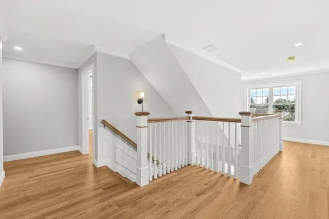 a view of a hallway with wooden floor and stairs