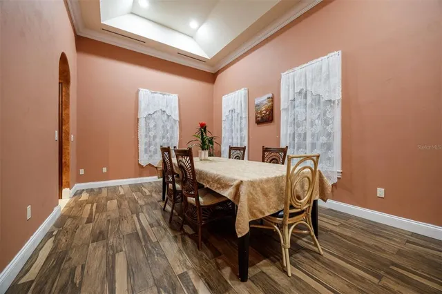 a spacious bedroom with a large bed a chandelier and dresser
