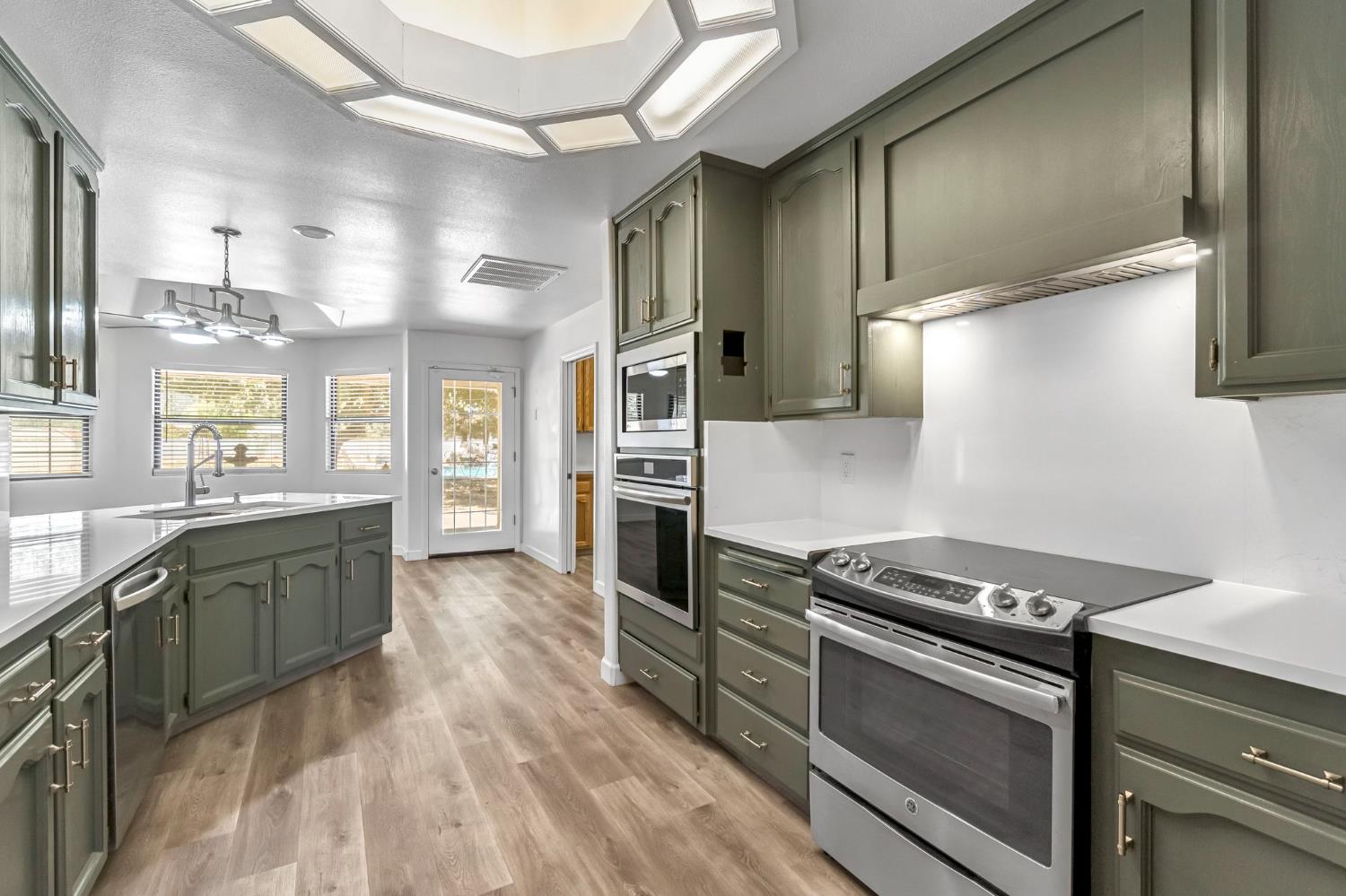 36065 Manon Avenue Madera, CA 93636 - Photo 12 of 50 a kitchen with stainless steel appliances granite countertop a stove and a refrigerator