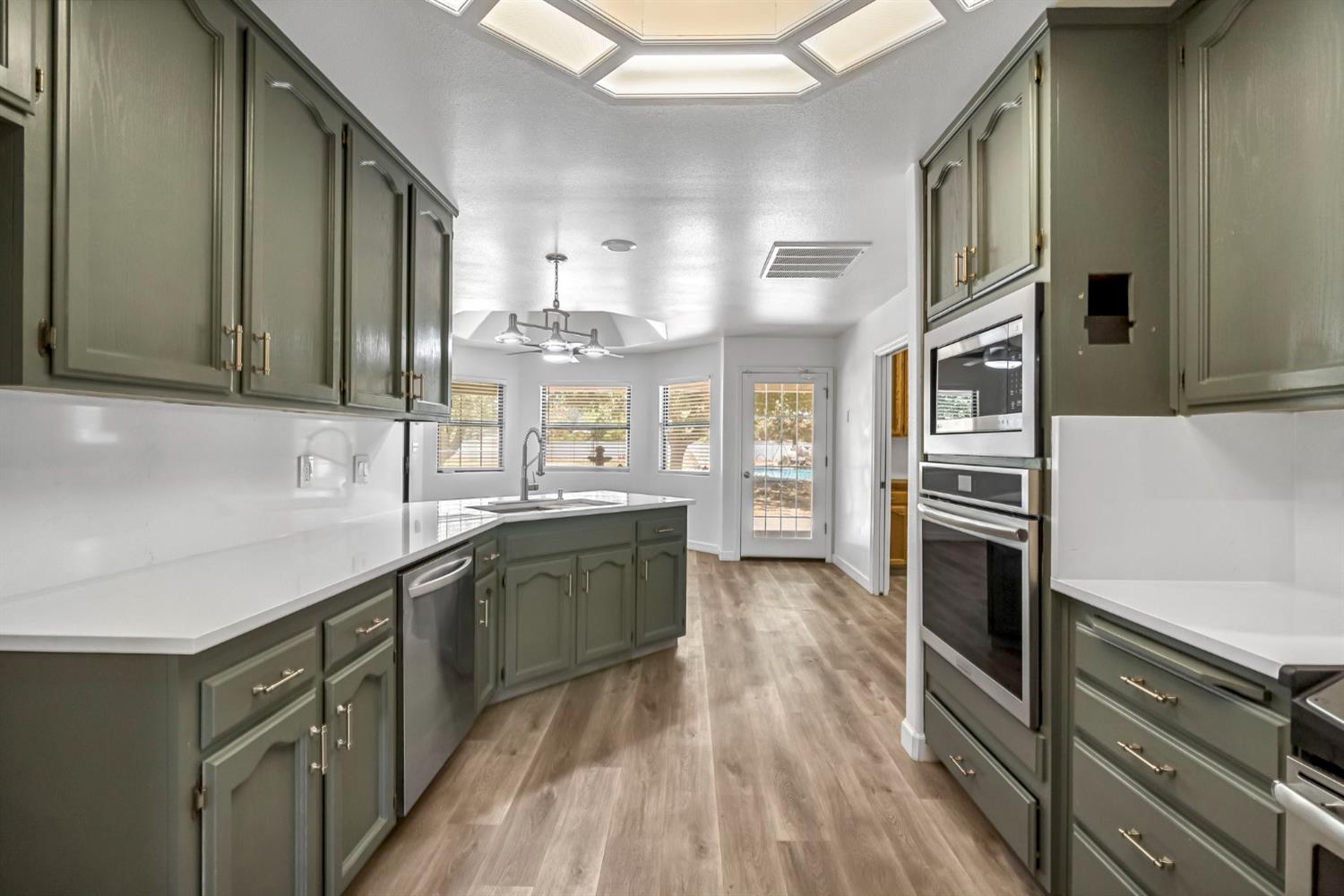 36065 Manon Avenue Madera, CA 93636 - Photo 13 of 50 a kitchen with stainless steel appliances granite countertop a stove and cabinets
