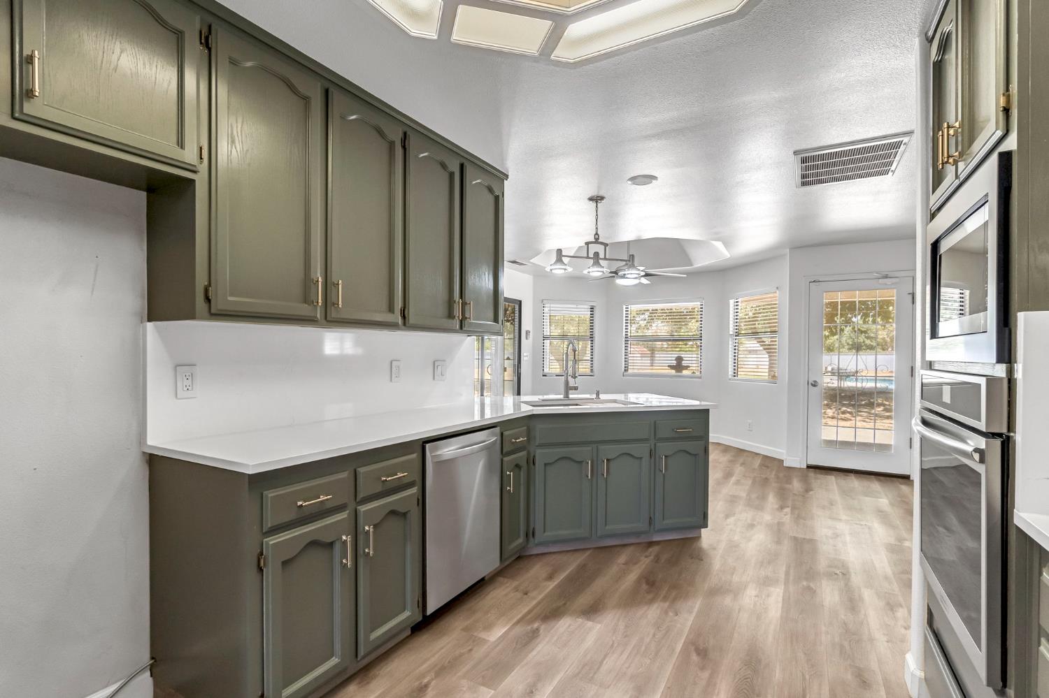 36065 Manon Avenue Madera, CA 93636 - Photo 14 of 50 a kitchen with stainless steel appliances granite countertop a stove a sink and a refrigerator