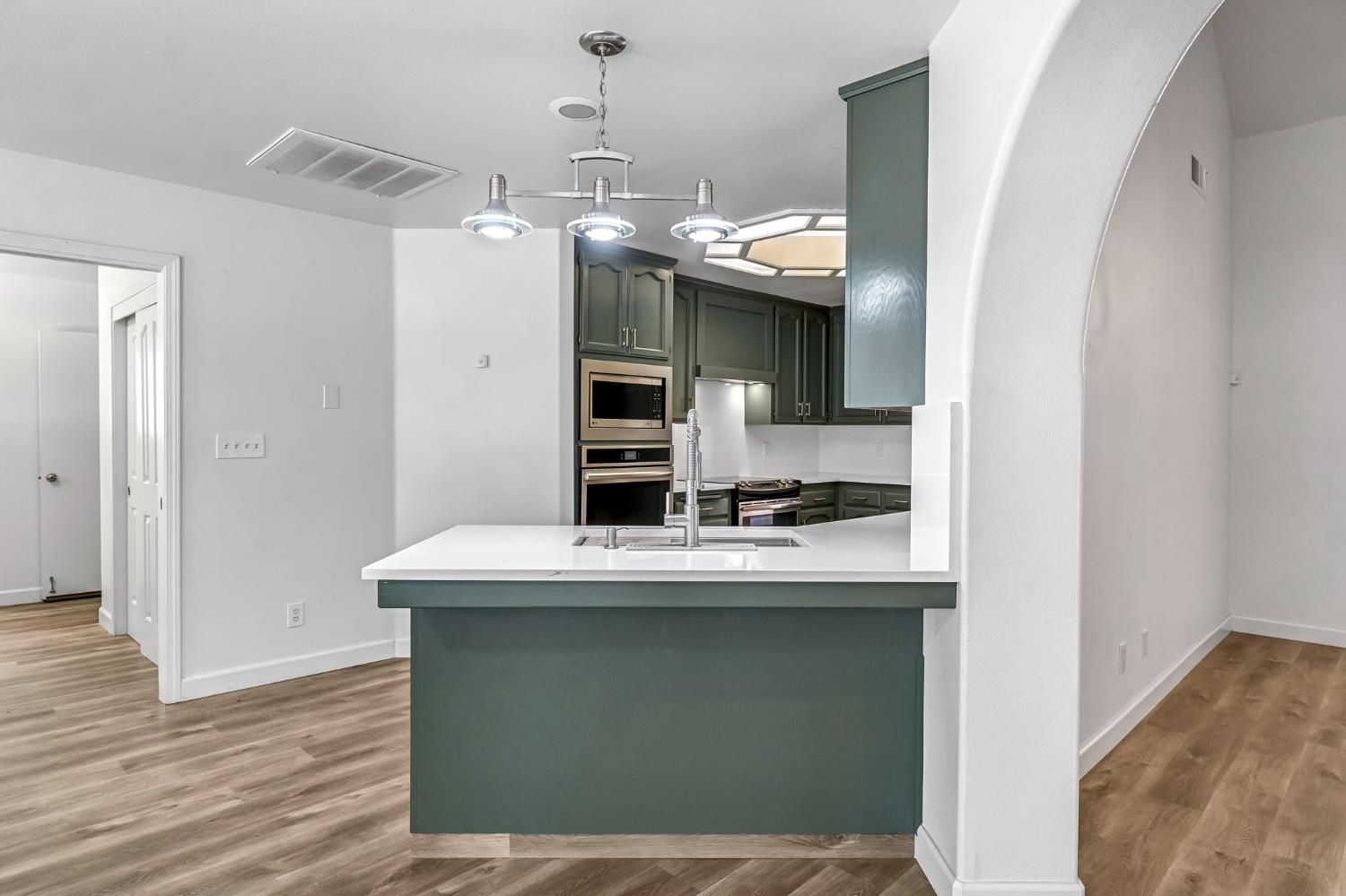 36065 Manon Avenue Madera, CA 93636 - Photo 10 of 50 a kitchen with kitchen island stainless steel appliances a sink and refrigerator