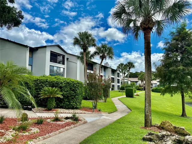 a front view of a house with garden and trees