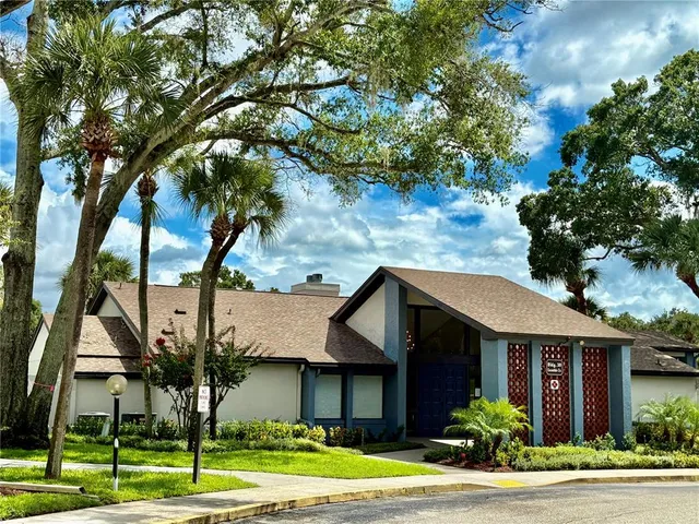 a front view of a house with a yard and potted plants