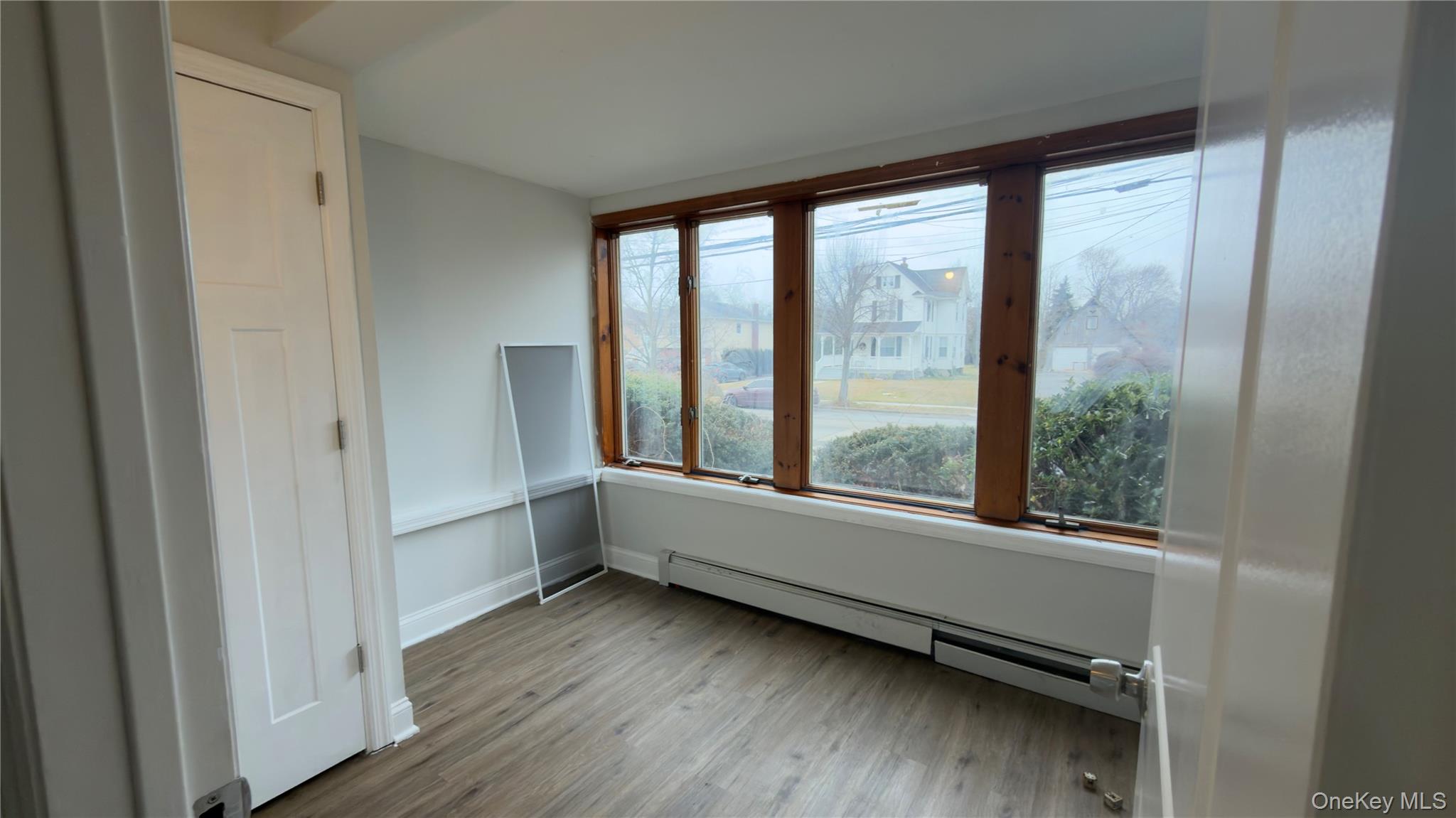 225 Church Street, Unit 2 Freeport, NY 11520 - Photo 11 of 18 a view of an empty room with wooden floor and a window