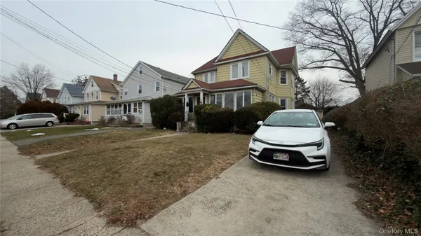 a car parked in front of a white house