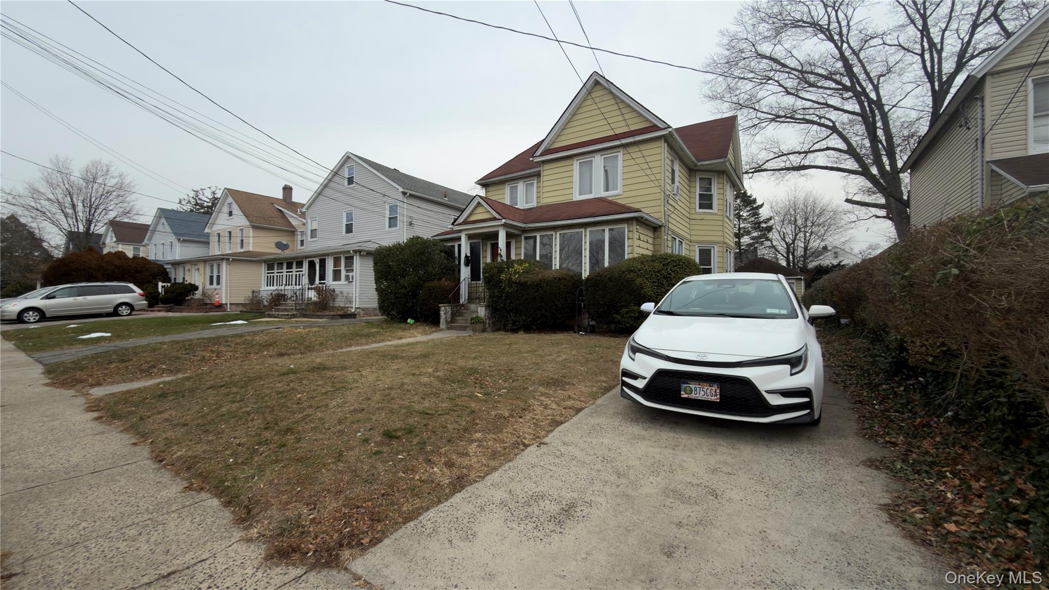 225 Church Street, Unit 2 Freeport, NY 11520 - Photo 4 of 18 a car parked in front of a white house