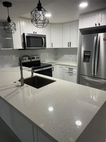 a kitchen with stainless steel appliances a microwave a sink and a refrigerator