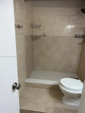 a bathroom with a toilet and a shower