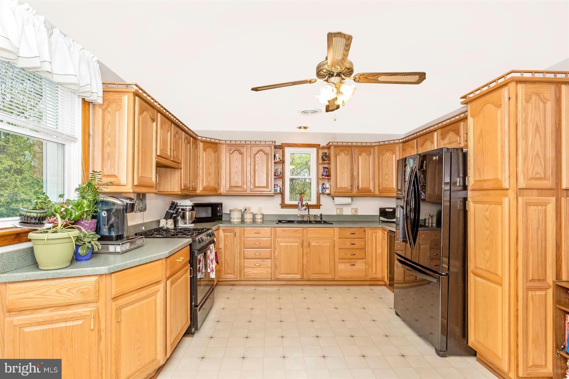 4834 Old Swimming Pool Road Frederick, MD 21703 - Photo 3 of 27 a kitchen with a refrigerator a sink and dishwasher with wooden floor