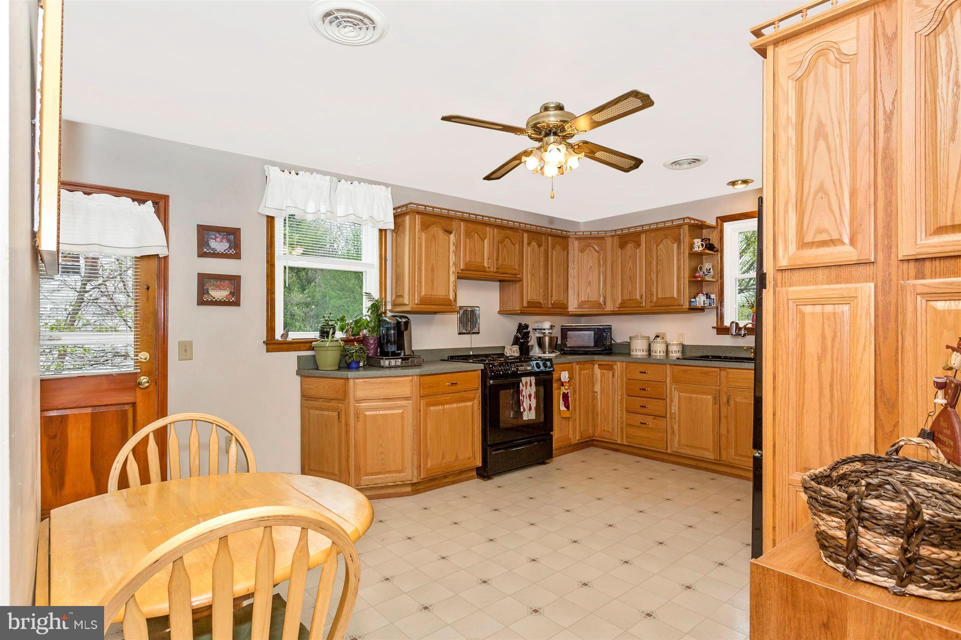 4834 Old Swimming Pool Road Frederick, MD 21703 - Photo 5 of 27 a kitchen with stainless steel appliances a refrigerator a stove a sink dishwasher and a dining table with wooden floor