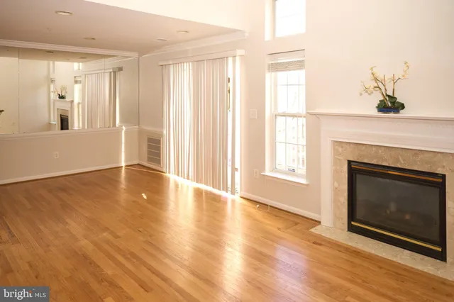 a view of an empty room with window and fireplace