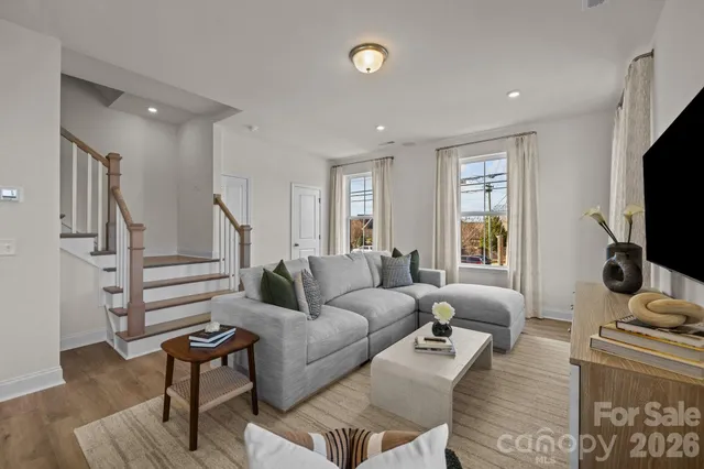 a living room with furniture a flat screen tv and a window
