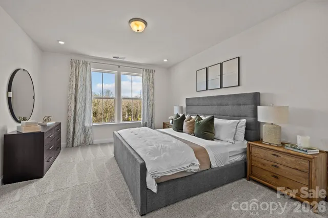 a bedroom with a bed a dresser next to a window