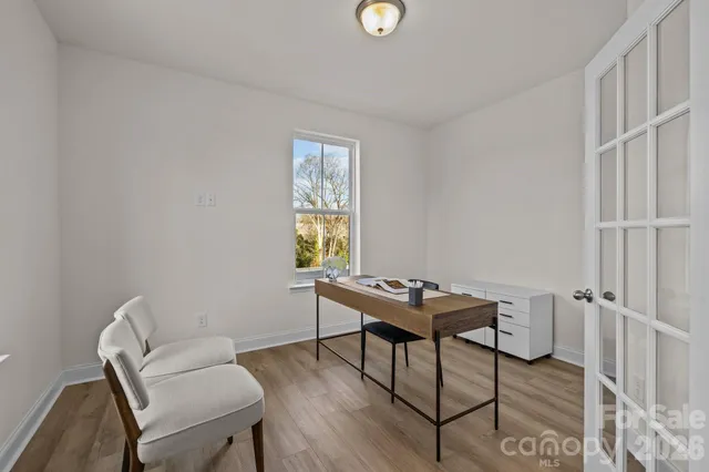 a view of a workspace with furniture and a window