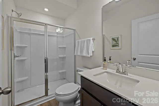 a bathroom with a granite countertop sink a toilet and shower