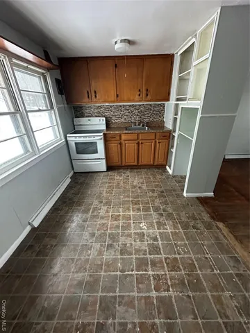 a view of a kitchen with wooden cabinets and a stove top oven