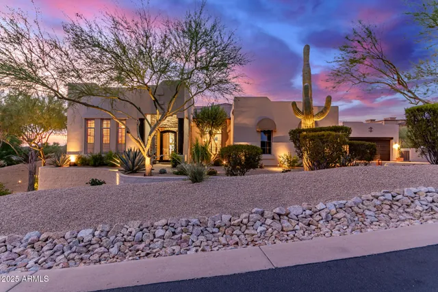 a front view of a house with a yard and a tree