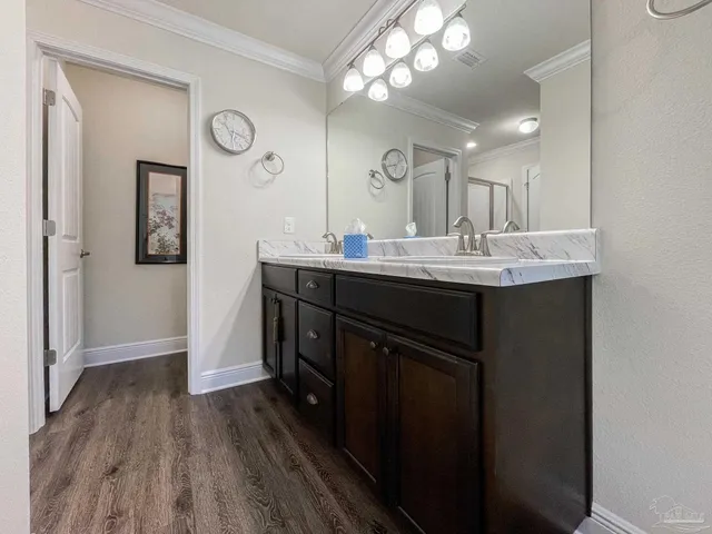 a kitchen with a sink a mirror and wooden floor