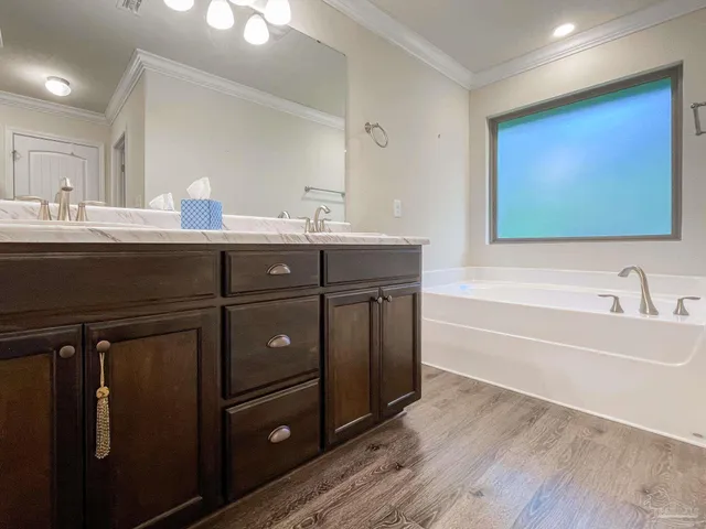 a bathroom with a tub sink and mirror