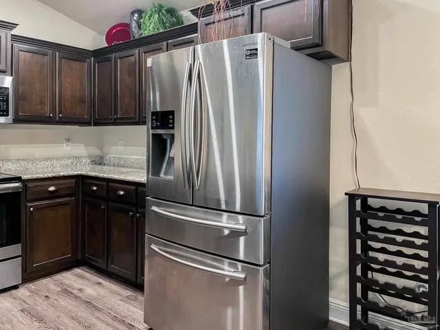 a kitchen with granite countertop stainless steel appliances and wooden cabinets