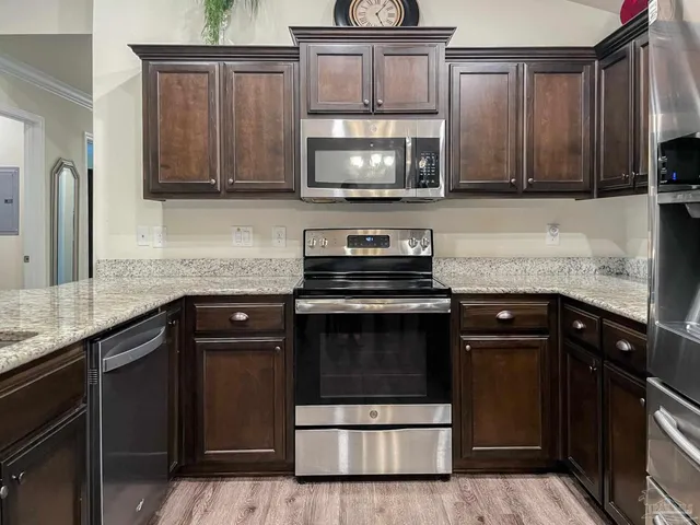a kitchen with granite countertop a stove microwave and sink