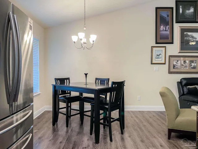 a view of a dining room with furniture a chandelier and wooden floor