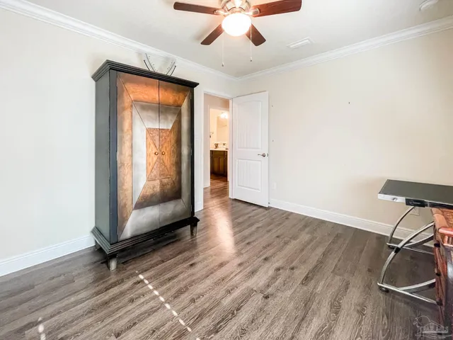 a view of a livingroom with wooden floor and a ceiling fan