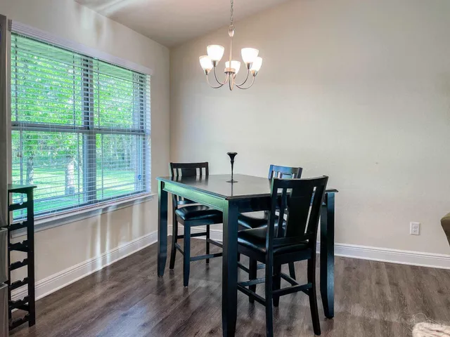 a view of a dining room with furniture a chandelier and wooden floor
