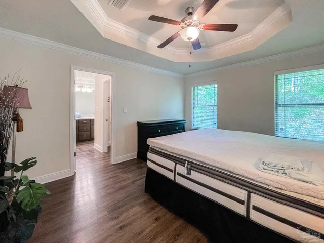 a bedroom with a large bed and a chandelier
