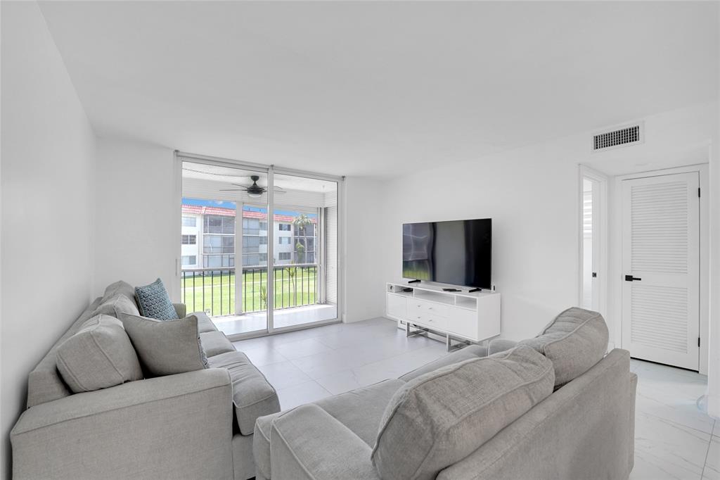 8911 South Hollybrook Boulevard, Unit 201 Pembroke Pines, FL 33025 - Photo 11 of 31 a living room with furniture and a flat screen tv