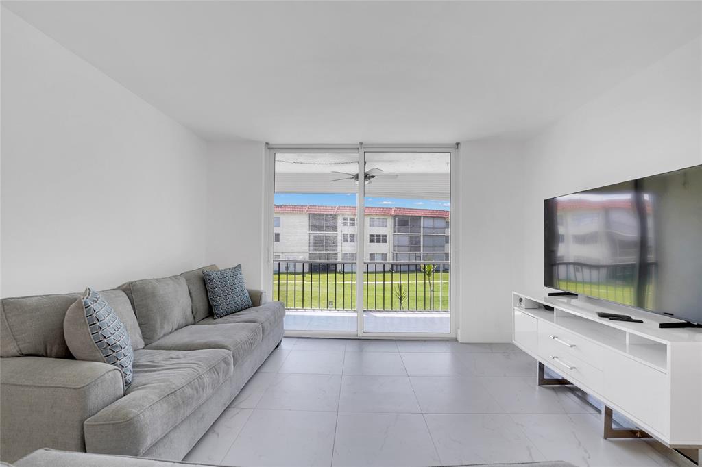 8911 South Hollybrook Boulevard, Unit 201 Pembroke Pines, FL 33025 - Photo 12 of 31 a living room with furniture and a flat screen tv