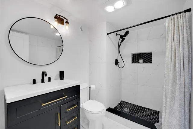 a bathroom with a sink a toilet and a mirror