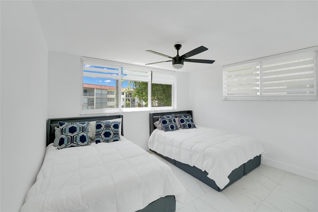8911 South Hollybrook Boulevard, Unit 201 Pembroke Pines, FL 33025 - Photo 20 of 31 a bedroom with a bed a window and a chandelier