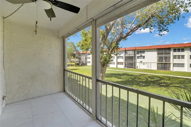 a view of a porch with a floor to ceiling window and a yard