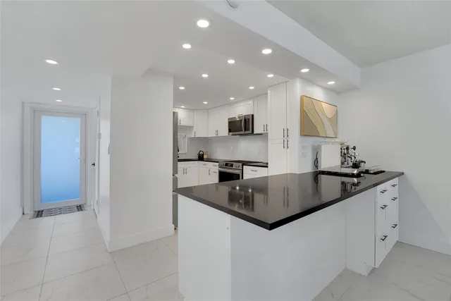 a kitchen with stainless steel appliances granite countertop a sink and a stove