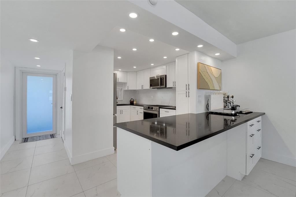 8911 South Hollybrook Boulevard, Unit 201 Pembroke Pines, FL 33025 - Photo 3 of 31 a kitchen with stainless steel appliances granite countertop a sink and a stove