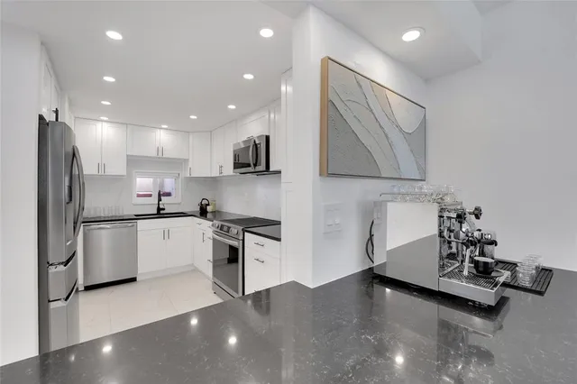 a kitchen with stainless steel appliances a refrigerator sink and microwave