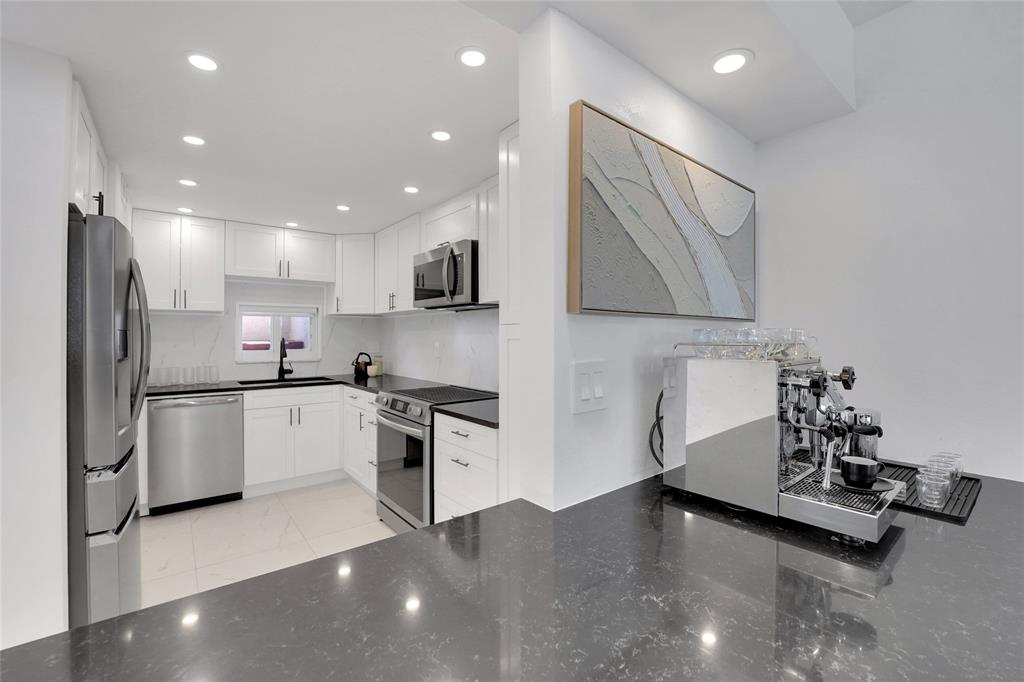 8911 South Hollybrook Boulevard, Unit 201 Pembroke Pines, FL 33025 - Photo 4 of 31 a kitchen with stainless steel appliances a refrigerator sink and microwave