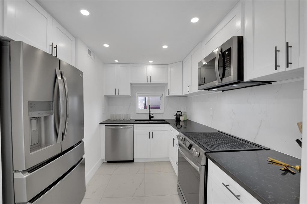 8911 South Hollybrook Boulevard, Unit 201 Pembroke Pines, FL 33025 - Photo 7 of 31 a kitchen with a sink a refrigerator and a stove top oven with wooden floor