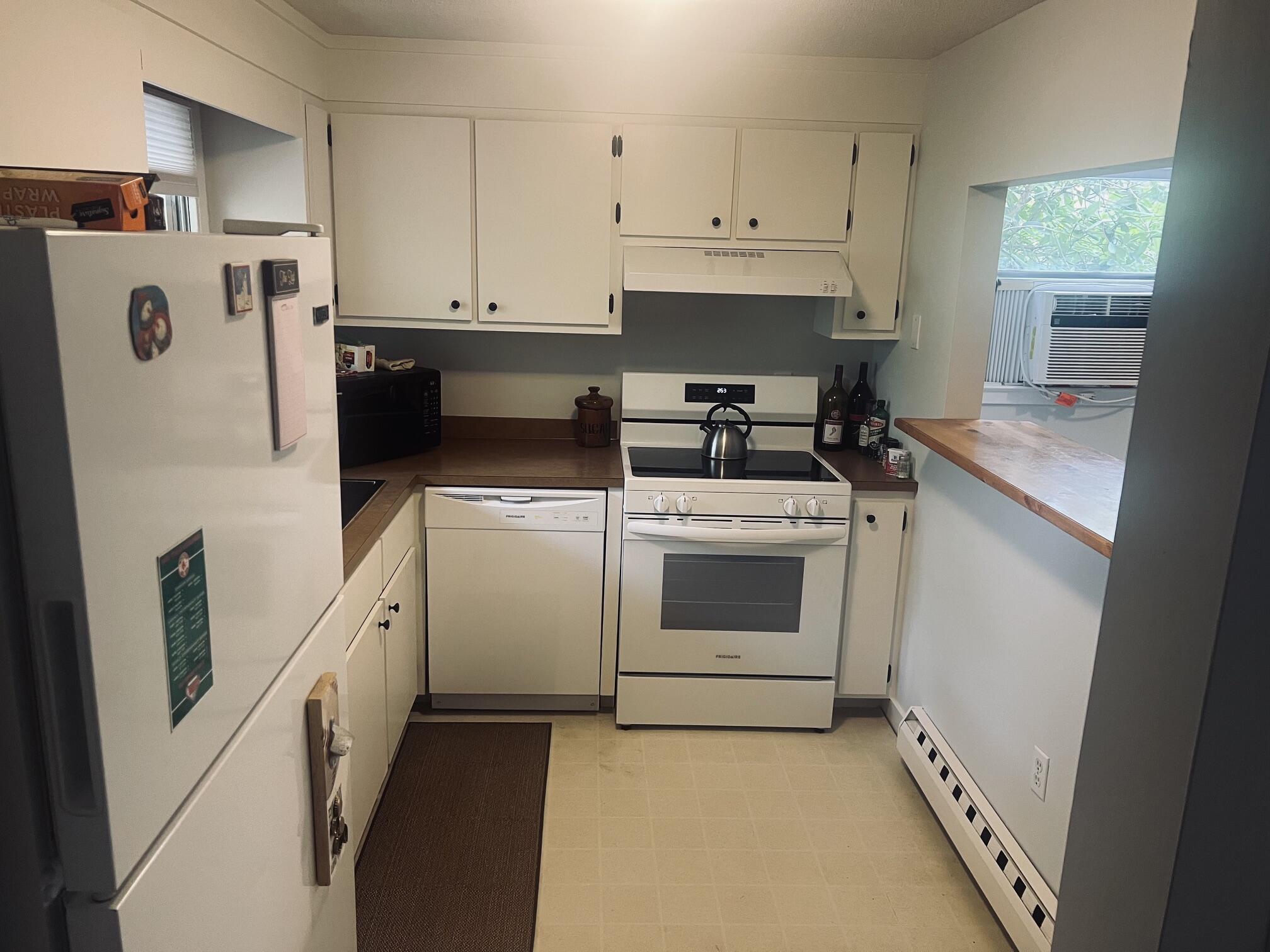 1431 Iyannough Road, Unit 1 Centerville, MA 02632 - Photo 9 of 28 a kitchen with white cabinets and white appliances