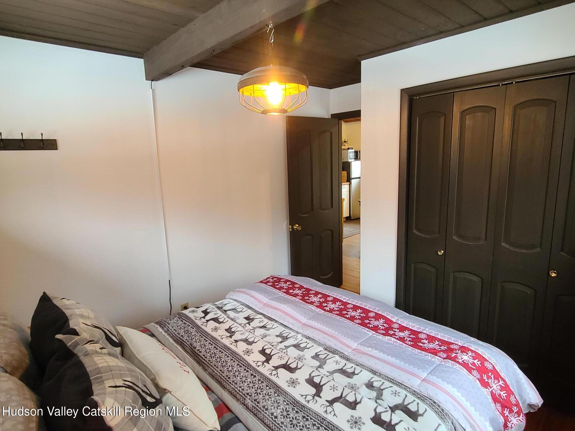 11 Rose Mountain Road Pine Hill, NY 12465 - Photo 15 of 26 a bedroom with a bed and a lamp