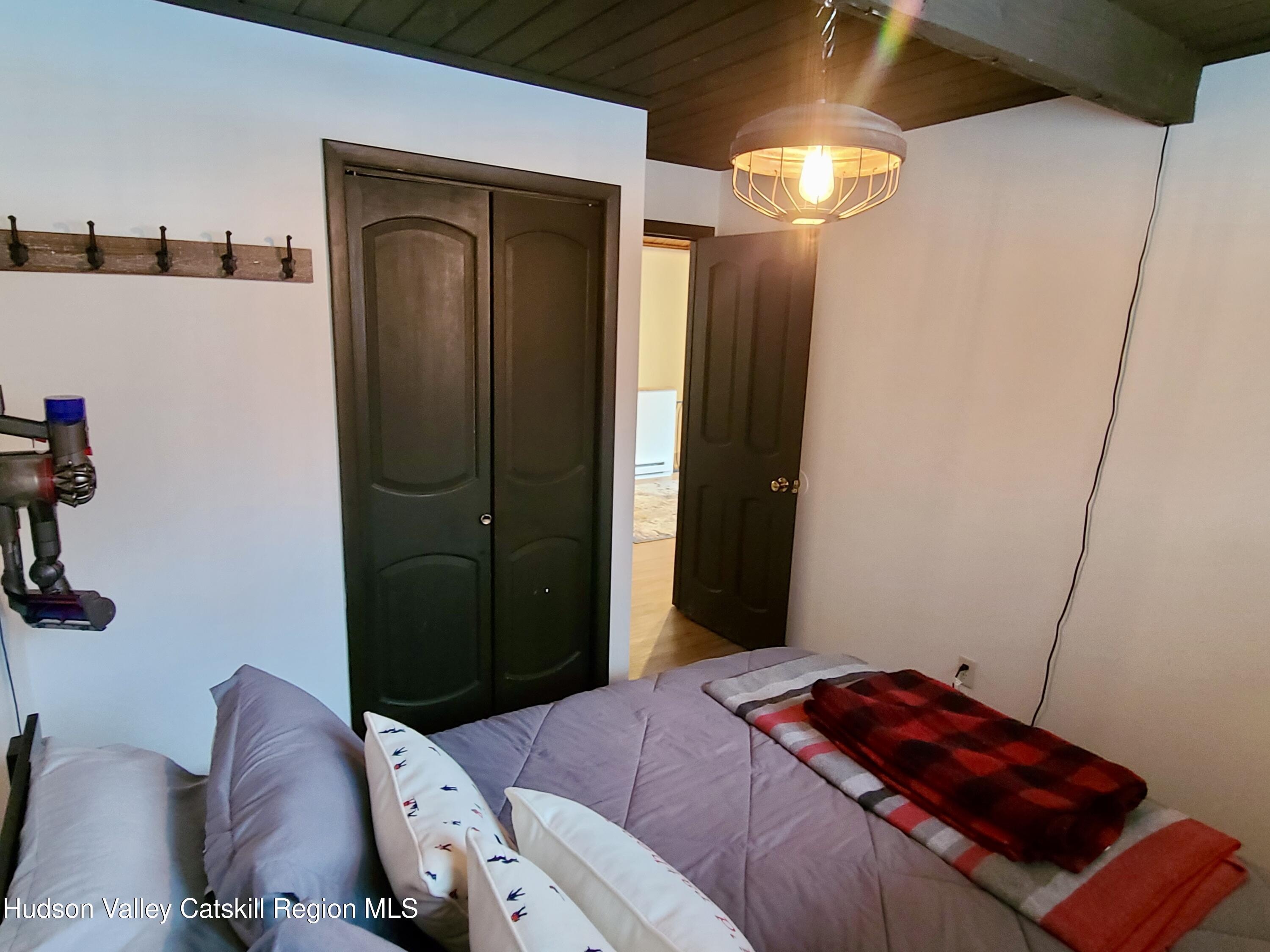 11 Rose Mountain Road Pine Hill, NY 12465 - Photo 18 of 26 a bedroom with a bed and a chandelier