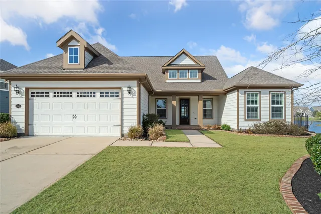 a front view of a house with a yard outdoor seating and garage