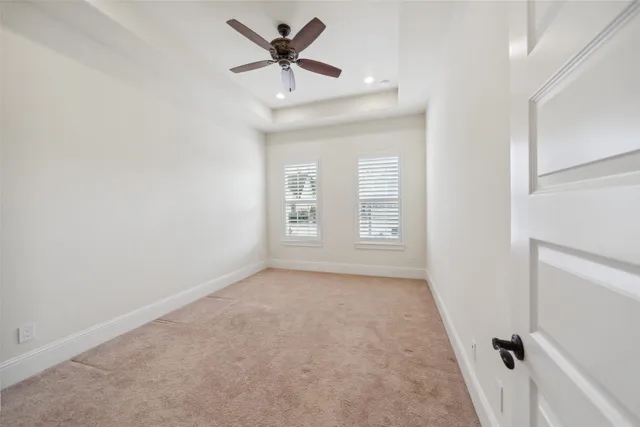 an empty room with a window and a ceiling fan